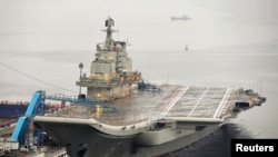 FILE - China's first aircraft carrier, renovated from an old aircraft carrier bought from Ukraine, is shown docked in Dalian, Liaoning province in 2012. A senior U.S. Navy delegation toured the ship this week.