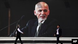 FILE - In this Aug. 14, 2021 file photo, a mural of Afghan President Ashraf Ghani hangs at Hamid Karzai International Airport, in Kabul, Afghanistan.