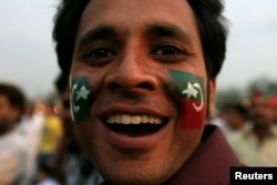 A supporter of the political party Pakistan Tehreek-e- Insaf (PTI) with party flags painted on his face attends a rally in Lahore, March 23, 2013.