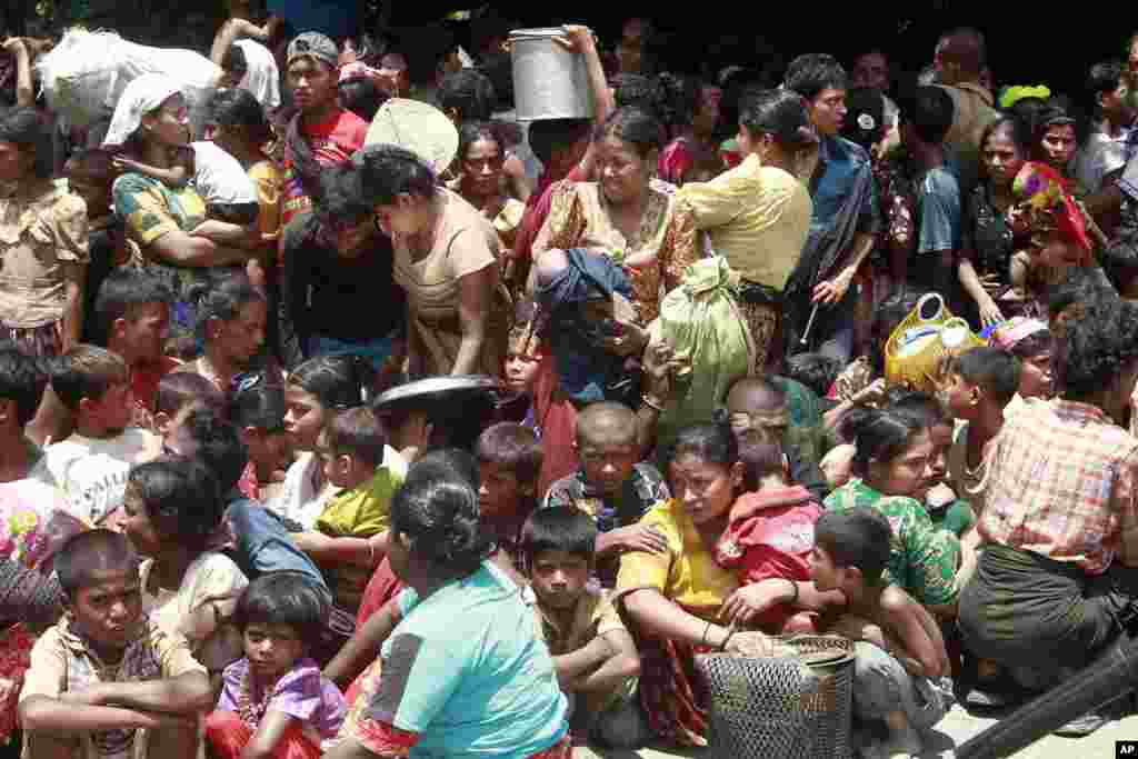 Muslims women and children from villages gather before being relocated to secure areas in Sittwe, capital of Rakhine state in western Burma, where sectarian violence is ongoing, June 12, 2012.
