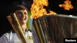 Torchbearer Tyler Rix smiles after lighting the Olympic Cauldron during the Olympic torch relay celebrations in Hyde Park, London, July 26, 2012. 