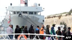 Some of the migrants who were stuck on a ship since their rescue in the Mediterranean 10 days ago, disembark in Valletta, Malta on April 13, 2019 after four European countries agreed to take them in. - All 62 migrants on the Alan Kurdi ship will be disemb