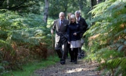 FILE - Britain's Prince Philip (L) is escorted during a visit to a 'The Conservation Volunteers' (TCV) conservation project at the Dersingham Bog Nature Reserve, on the Royal Sandringham Estate, in Sandringham, southern England, Sept. 30, 2013.