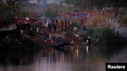  Refugees, who have fled a flare-up in fighting between the Myanmar army and insurgent groups and settled temporarily on the Moei River Bank, are seen on the Thai-Myanmar border, in Mae Sot, Thailand, Jan. 7, 2022. 
