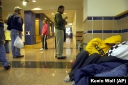 FILE - A student sleeps in the hallway of Hall Memorial Building on the campus of Gallaudet University in Washington, Oct. 6, 2006.