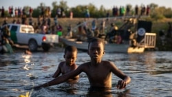 Two Haitians brothers cross the Rio Bravo natural border between Del Rio and Ciudad Acuña, Sept. 20, 2021. (Stephania Corpi/VOA)
