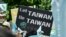 FILE - A demonstrator holds a placard in support of Taiwan during a rally ahead of an identity referendum in Taipei, October 20, 2018.