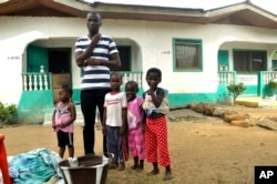 James Harris, the widower of Salome Karwah, and his children pose for a photographs outside his house in Monrovia, Liberia, March 2, 2017.