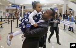 Abdisellam Hassen Ahmed, a Somali refugee who had been stuck in limbo after President Donald Trump temporarily banned refugee entries, holds his 2-year-old daughter, Taslim, after meeting her for the first time upon arriving at Salt Lake International Airport in Salt Lake City, Utah, Feb. 10, 2017.