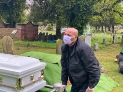 Yilma Asfaw grieving at the funeral of his wife, Wegene Debele of Takoma Park, Maryland. They have been together for 25 years. She was eight months pregnant when she contracted the coronavirus.