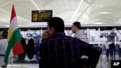 Hours ahead of a flight ban threatened by the central government, passengers file through Irbil international airport Friday, September 29, 2017. 
