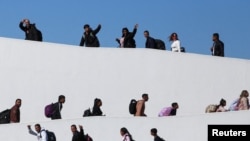 FILE - Migrants who requested an appointment for asylum in the United States walk towards El Chaparral, at the border between Mexico and the U.S, in Tijuana, Mexico Nov. 4, 2024. 