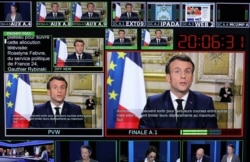 Screens show France's President Emmanuel Macron addressing the nation about the coronavirus outbreak, at TV broadcast studios of the France 24 channel, in Issy-Les-Moulineaux, near Paris, France, March 12, 2020.
