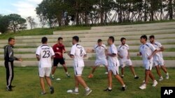 FILE - Palestinian football players warm-up during a training session at the Asian Games athletes’ village in Incheon, South Korea.