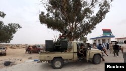 FILE - Fighters loyal to Libya's internationally recognized government are seen after taking control of Watiya airbase, southwest of Tripoli, May 18, 2020.