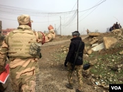 Iraqi soldiers travel to the frontlines as families flee in Mosul, Iraq, Jan. 23, 2017. (H. Murdock/VOA)