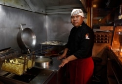 Rolando Condori, chef at his own fast food restaurant, poses for a portrait in his restaurant's kitchen in El Alto, Bolivia, Sept. 14, 2019.
