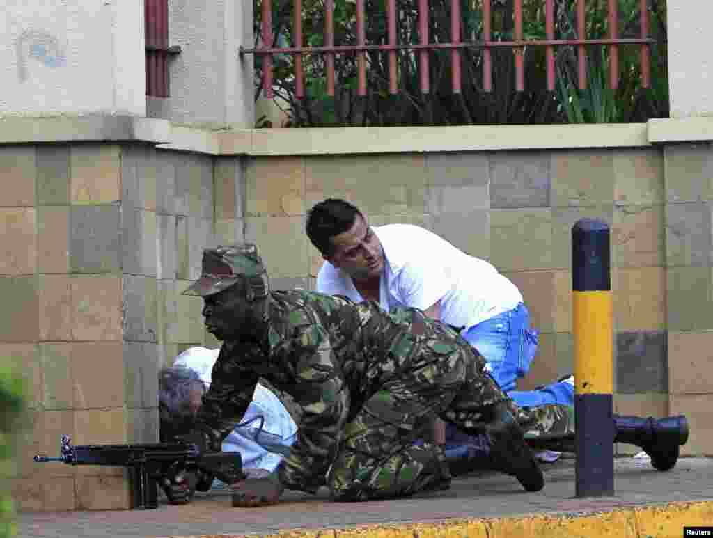 A Kenyan army soldier takes cover behind a wall at Westgate Shopping Center in Nairobi September 21, 2013.
