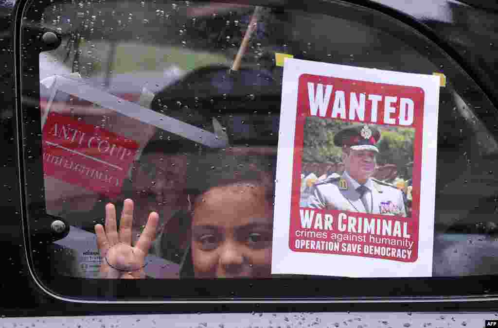 Protesters hold signs during a demonstration condemning the recent deadly military crackdown on supporters of ousted Egyptian President Mohamed Morsi in Cairo on August 17, 2013, at the New Mosque in Istanbul. 