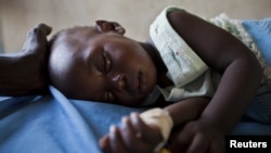 A young girl with malaria rests in the inpatient ward of the Malualkon Primary Health Care Center in Malualkon, in the South Sudanese state of Northern Bahr el-Ghazal, June 1, 2012. 