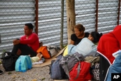 Venezuelan migrants rest with their belongings after crossing the border to Pacaraima, in Roraima state, Brazil, Aug. 20, 2018.