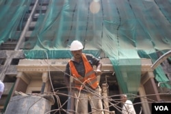 Four years after protesters stormed the ruling party headquarters under ousted President Hosni Mubarak, construction workers are demolishing the charred building, a symbol of the 2011 uprising near Tahrir Square, Cairo, June 4, 2015. (H. El Rasam)