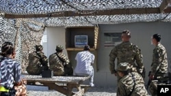 US troops watch cable news coverage of the death of al-Qaida leader Osama bin Laden at the Bagram air field, Afghanistan, May 2, 2011