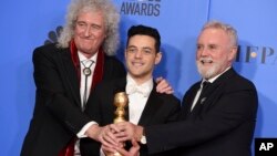 Brian May, left, and Roger Taylor, right, of Queen, and Rami Malek pose with the award for best motion picture, drama for "Bohemian Rhapsody" at the 76th annual Golden Globe Awards on Sunday, Jan. 6, 2019, in Beverly Hills, Calif. 