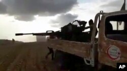 This frame grab from video provided by Baladi News Network, a Syrian opposition media outlet, is said to show Turkey-backed Syrian opposition fighters fire their weapons during clashes near the northern Syrian town of al-Bab, Aleppo province, Syria, Feb. 9, 2017.