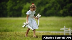 Стар Гай, 6 років, у місті Вако, Техас, допомагає замінити хрести на могилах тим, хто загиб під час протистояння членів «Храму народів» з федеральними агентами.