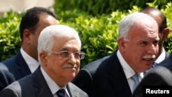 FILE - Palestinian President Mahmoud Abbas and his foreign minister Riyad al-Maliki (R) arrive for an Arab League Foreign Ministers emergency meeting at the league's headquarters in Cairo, Sept. 7, 2014.