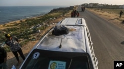 FILE - Palestinians inspect a vehicle with the logo of the World Central Kitchen wrecked by an Israeli airstrike in Deir al Balah, Gaza Strip, April 2, 2024. Seven aid workers were killed in the attack. 