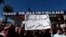 FILE - Syrian Druze hold up a placard in Arabic which reads "Sweida will not be your poisoned dagger in Syria's back" and stage a demonstration against Israeli incursions into Syrian territory in the southern province of Sweida, Syria, Feb. 25, 2025.