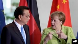 Kanselir Jerman Angela Merkel (kanan) bersma PM China Li Keqiang (kiri) dalam acara penandatanganan kontrak kerjasama di Berlin, 1 Juni 2017.