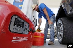 Aaron Berg fills up a gas can and his portable generator, Aug. 24, 2017, in Houston, as Hurricane Harvey intensifies in the Gulf of Mexico.