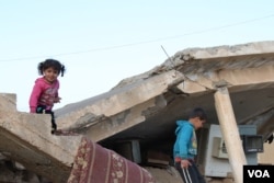 Children play on a bombed-out house in Tel Hamees, Syria, March 1, 2019. (H. Murdock/VOA)