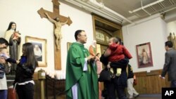 Father Luyen Dau greets members of his congregation at Visitation Parish, which offers mass in English, Spanish and Vietnamese.