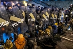 FILE - Police secure the road as demonstrators try to block traffic during a pro-choice protest in the center of Warsaw, Nov. 28, 2020.