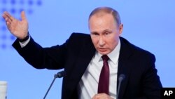 Russian President Vladimir Putin gestures as he speaks during his annual news conference in Moscow, Russia, Friday, Dec. 23, 2016.