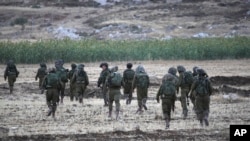 Israeli soldiers walk during an operation near Balata refugee camp in the West Bank city of Nablus,Tuesday, June 17, 2014. 