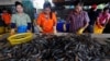 FILE - Myanmar migrant workers sort shrimp at a wholesale market for shrimp and other seafood in Mahachai, in Samut Sakhon province, Thailand, July 4, 2017.