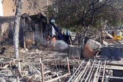 Afghans inspect damaged shops after fighting between the Taliban and Afghan security forces in Kunduz city, northern Afghanistan, Aug. 8, 2021.