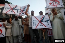 FILE - Protesters hold placards as they shout anti-American slogans during a protest against U.S. drone attacks in Karachi, Oct. 23, 2013.