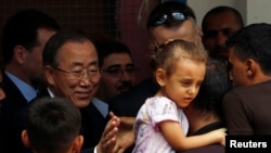 United Nations chief Ban Ki-moon greets a Palestinian man, whose house was destroyed, at a UN-run school for refugees in Gaza City on Oct. 14, 2014.