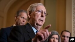 Senate Majority Leader Mitch McConnell, R-Ky., joined by Majority Whip John Thune, R-S.D., left, and Sen. Joni Ernst, R-Iowa, talks to reporters at the Capitol in Washington, Jan. 7, 2020. 