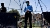 A police officer and paramilitary soldier stand guard at a checkpoint of a restricted area to help to contain the spread of new coronavirus, in Islamabad, Pakistan, June 13, 2020. 