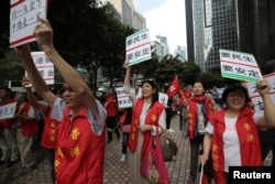 FILE - Supporters of visiting Zhang Dejiang, the chairman of China's National People's Congress, hold placards which read "Need livelihood, need stability", in Hong Kong on May 18, 2016.