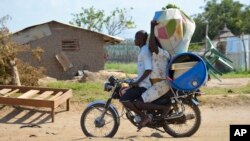 A couple flees on motorbike from the Jabel area of Juba, South Sudan, July 16, 2016. The United Nations refugee agency reports 26,000 fearful people have left the country this month.