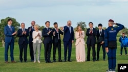 Лідери Групи семи в Італії аплодують і вітають парашутиста італійської армії після перегляду демонстраційного стрибка з парашутом, 13 червня 2024 р. AP/Domenico Stinellis