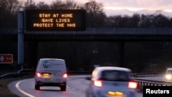 FILE - A government public health information message is seen on a roadside sign, amidst the spread of the coronavirus pandemic, near Milnathort, Scotland, Jan. 5, 2021. 